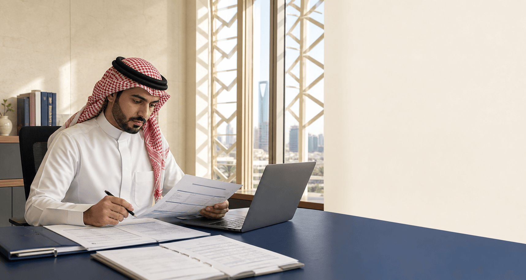 محاسب سعودي يراجع مستندات عملية مالية وقيدًا محاسبيًا داخل بيئة عمل مهنية في الرياض.